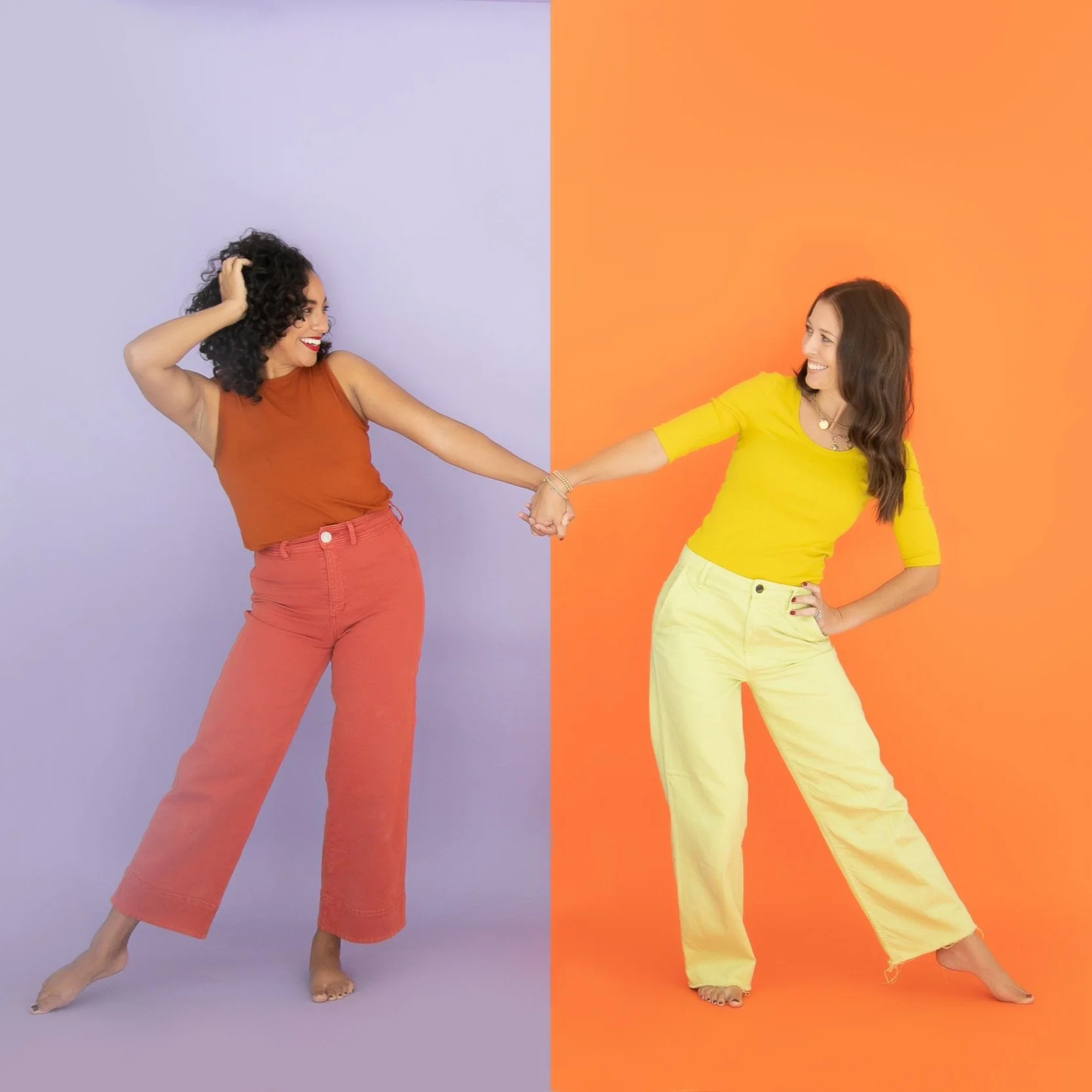 Colorful brand portrait two women holding hands in monochromatic outfit