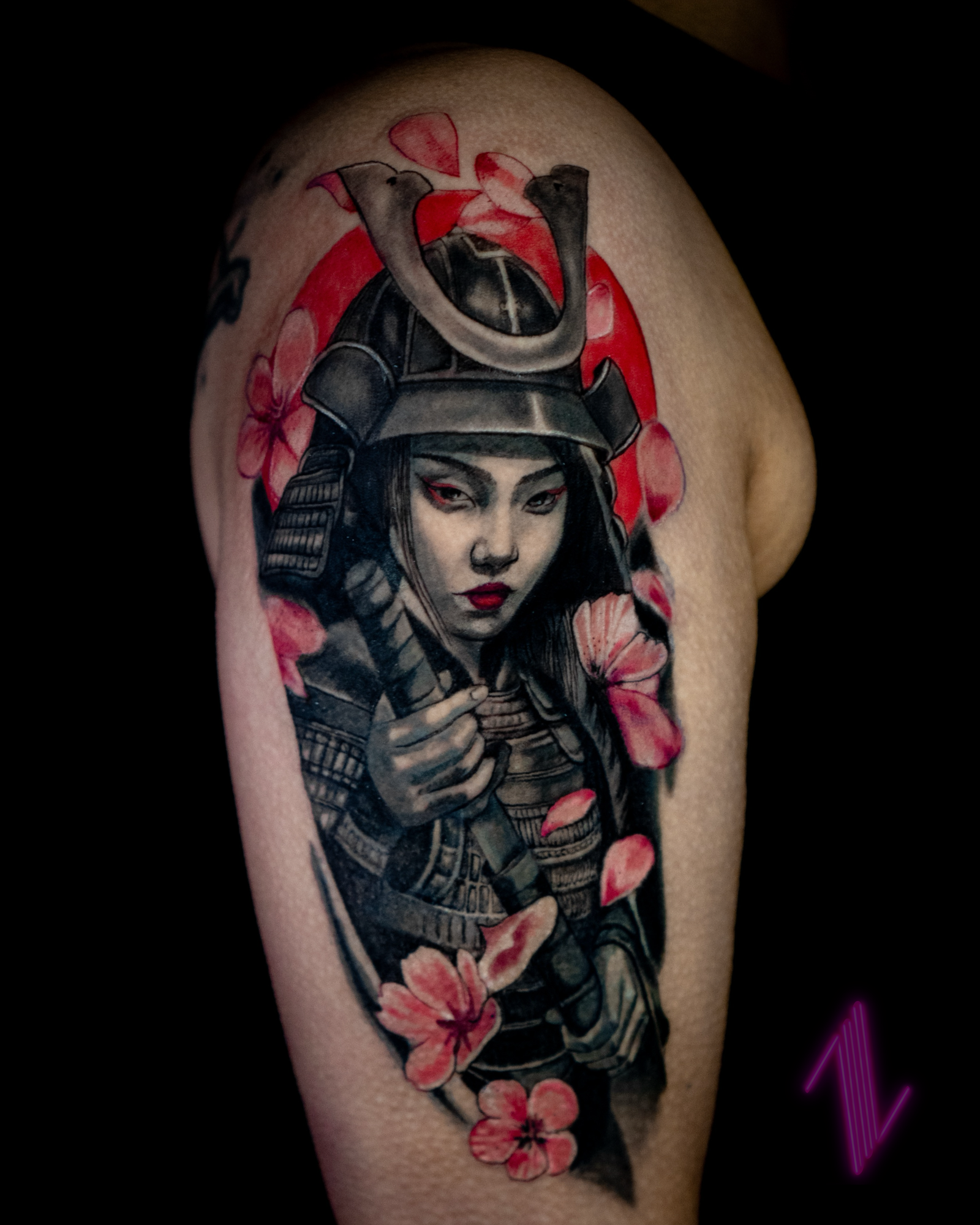 Tattoo of a woman in Japanese samurai armor with cherry blossoms, pointing her finger, with a fierce expression.
