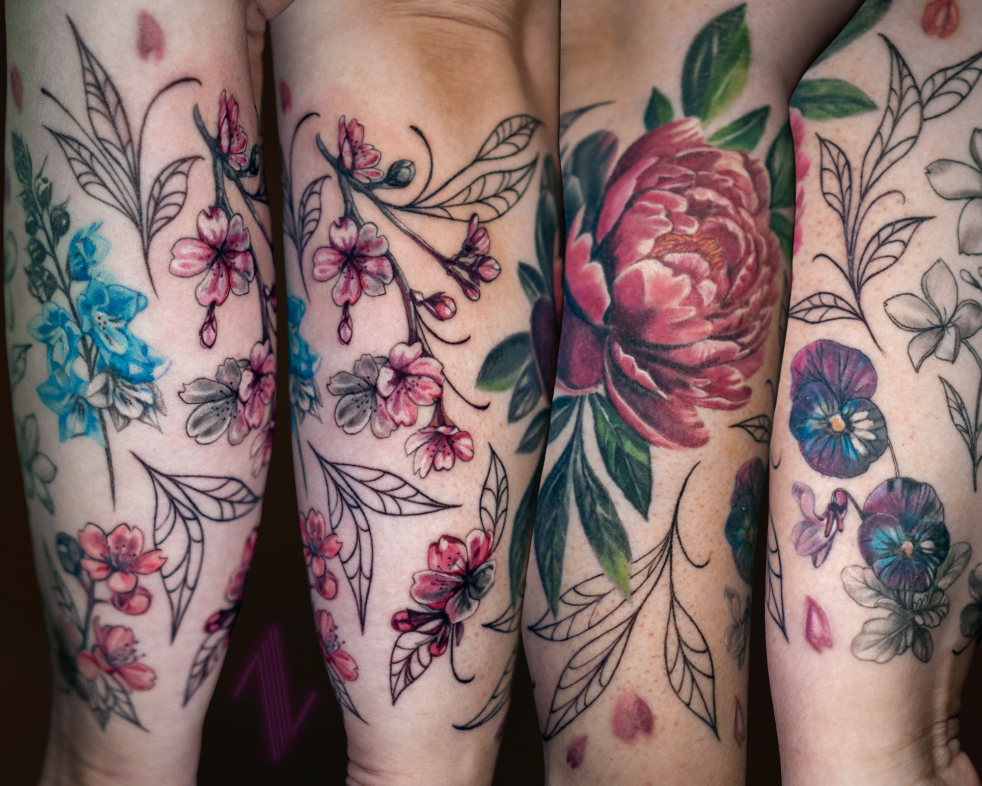 Close-up of four tattooed arms with floral designs, including pink cherry blossoms, a large peony, and various leaves with some areas left uncolored.