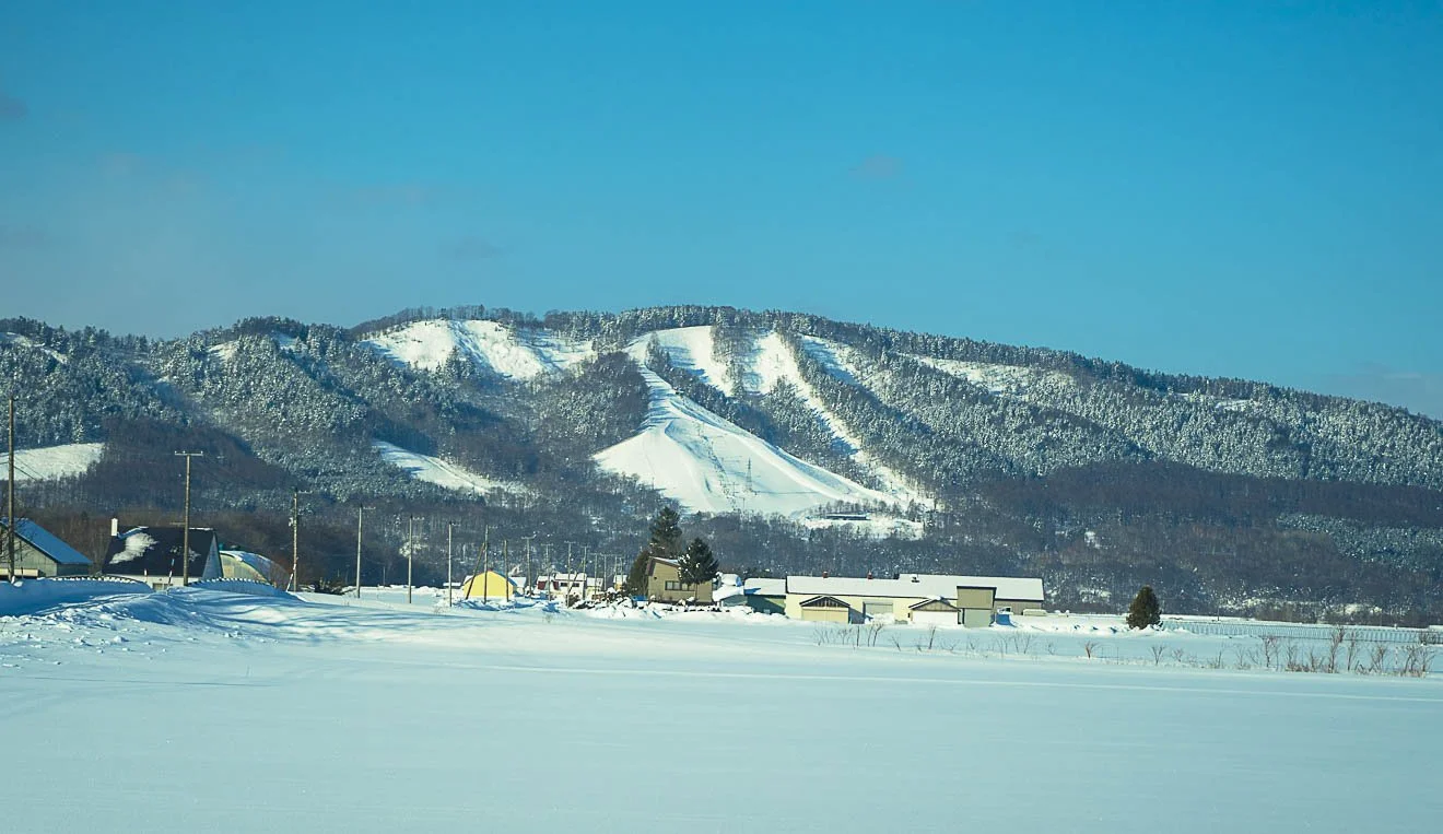 Snow-covered landscape with mountains and buildings in Hokkaido japan