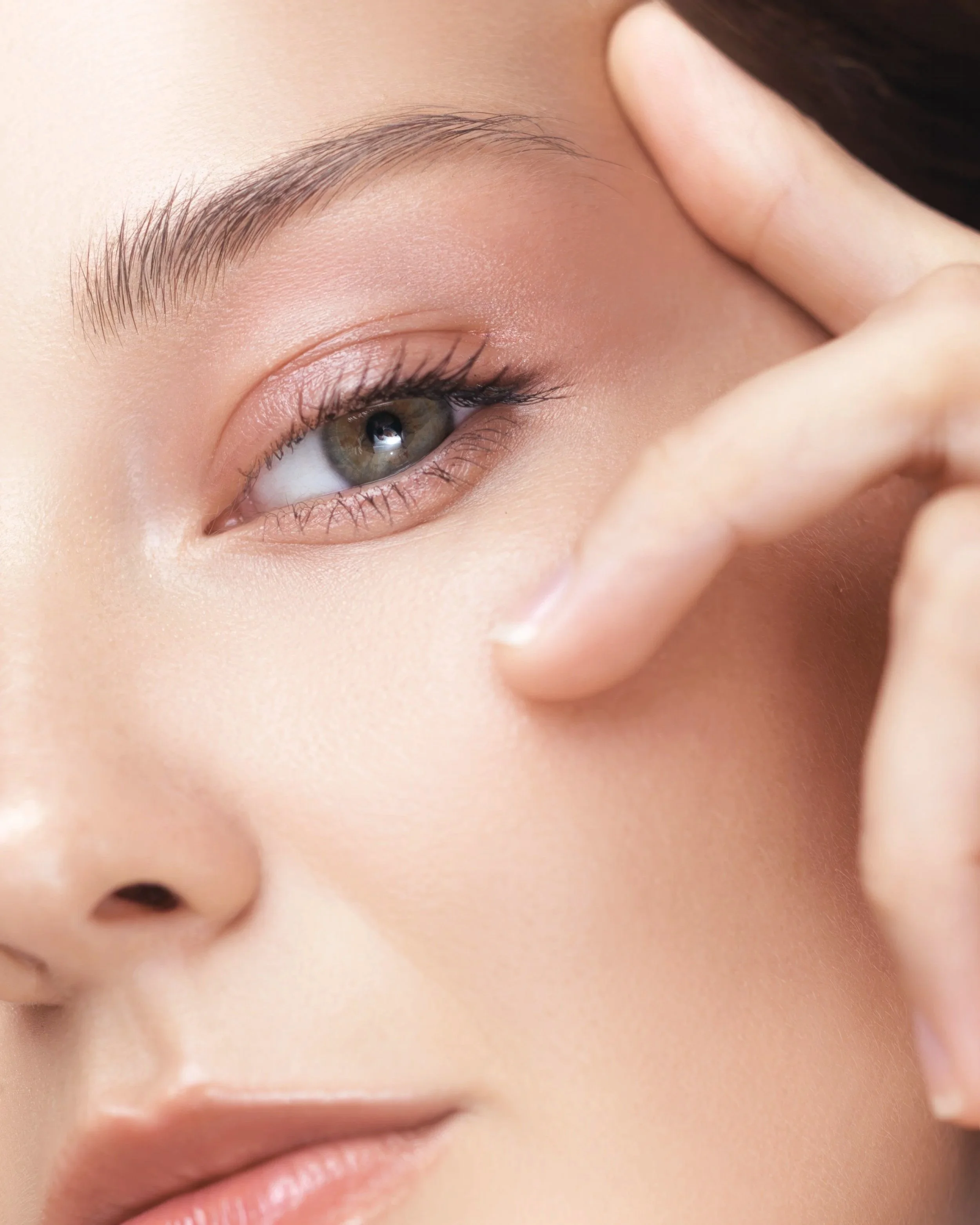 Close-up of a woman’s eye area highlighting eyelashes and brows, representing Latisse lash serum treatment for fuller-looking lashes.