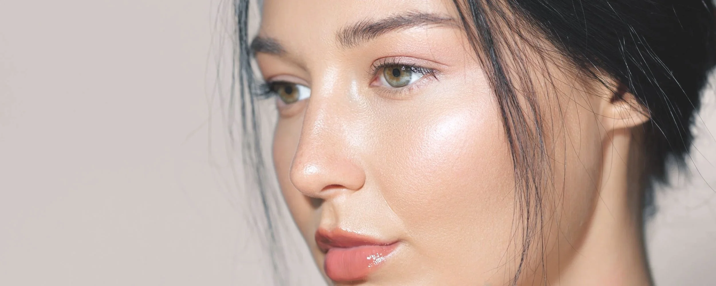 Close-up of a woman's face with natural makeup, focusing on her skin and eye details.