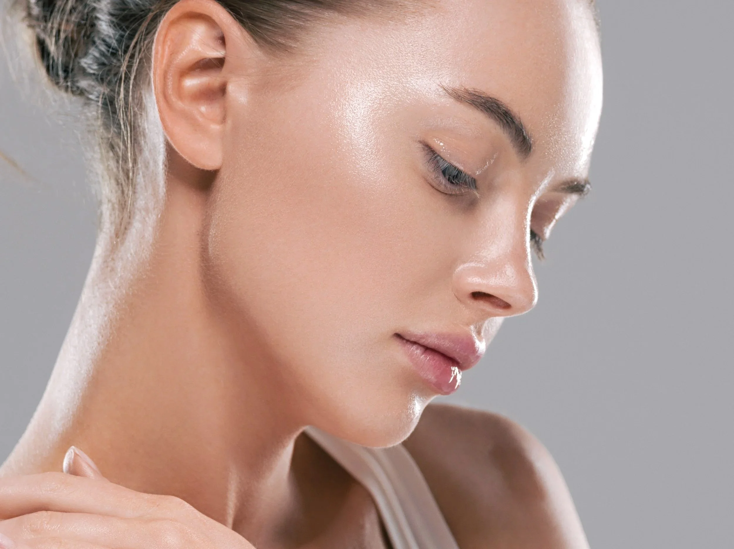Close-up of a woman's face with smooth, glowing skin and closed eyes
