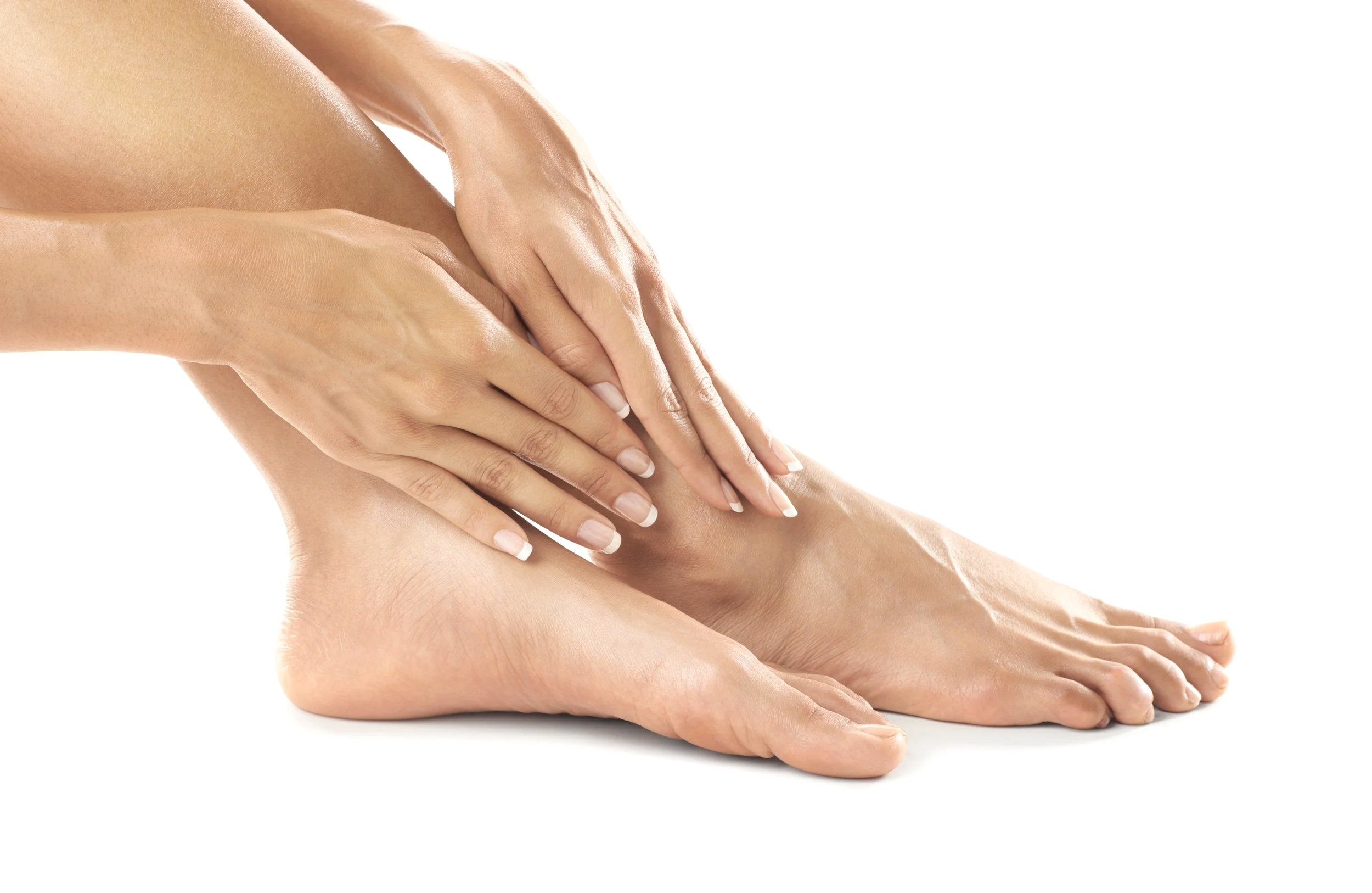 Close-up of a woman touching her bare foot, hands gently resting on her ankle and toes, with a white background.