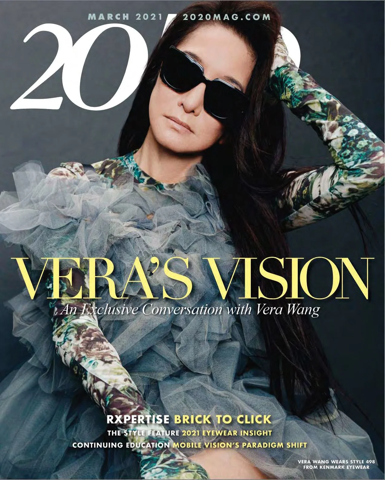Vera Wang posing on the cover of a magazine with dark hair and oversized black sunglasses, wearing a layered, ruffled dress with patterned long sleeves.