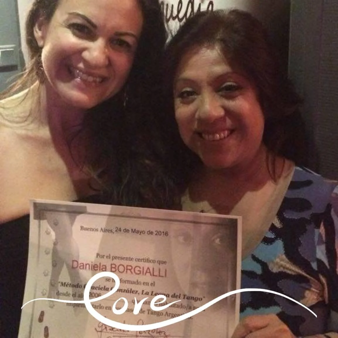 Two women smiling, holding a certificate dated May 24, 2016, in Buenos Aires, with the name Daniela Borgialli visible.
