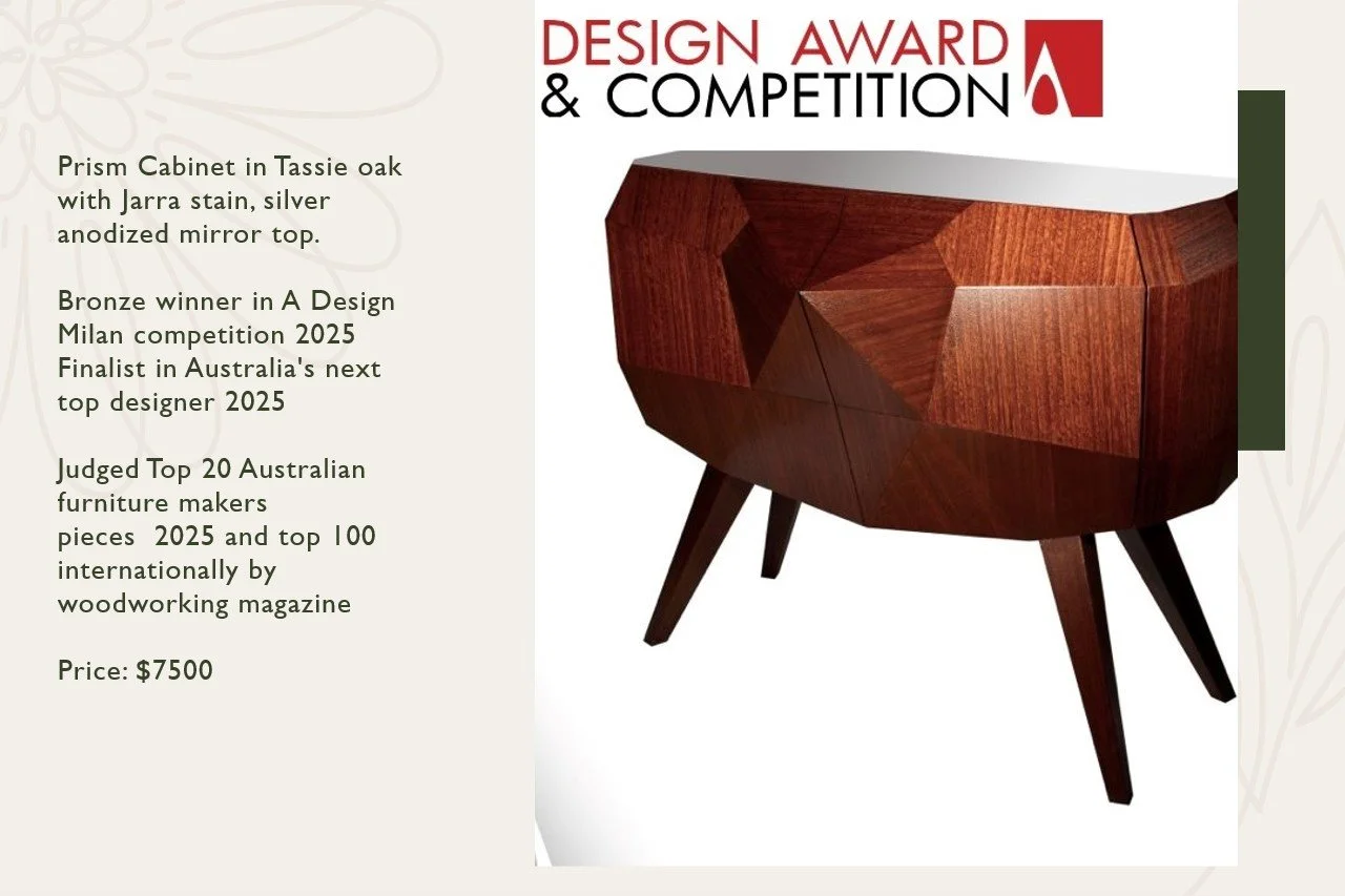 A wooden cabinet with geometric panels in tassie oak and jarra stain, set on four angled legs, displayed for a design award and competition.