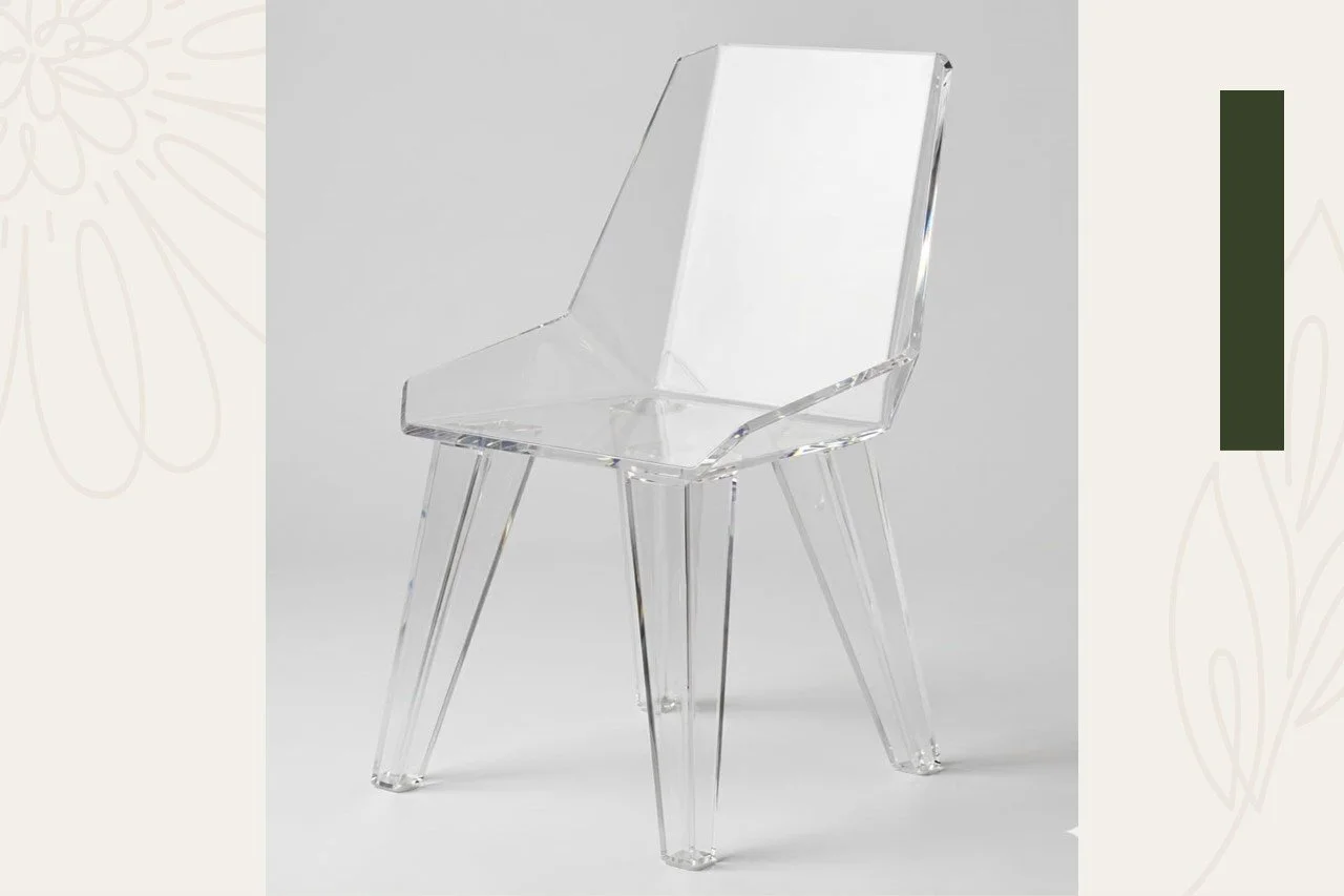 Clear acrylic chair with four angled legs on a light gray background.
