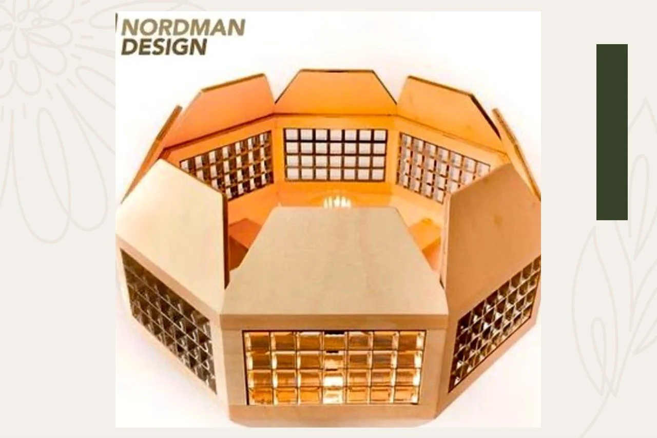 A model of a building with a central open space, featuring multiple wall sections with grid-like partitions, labeled 'Nordman Design'.