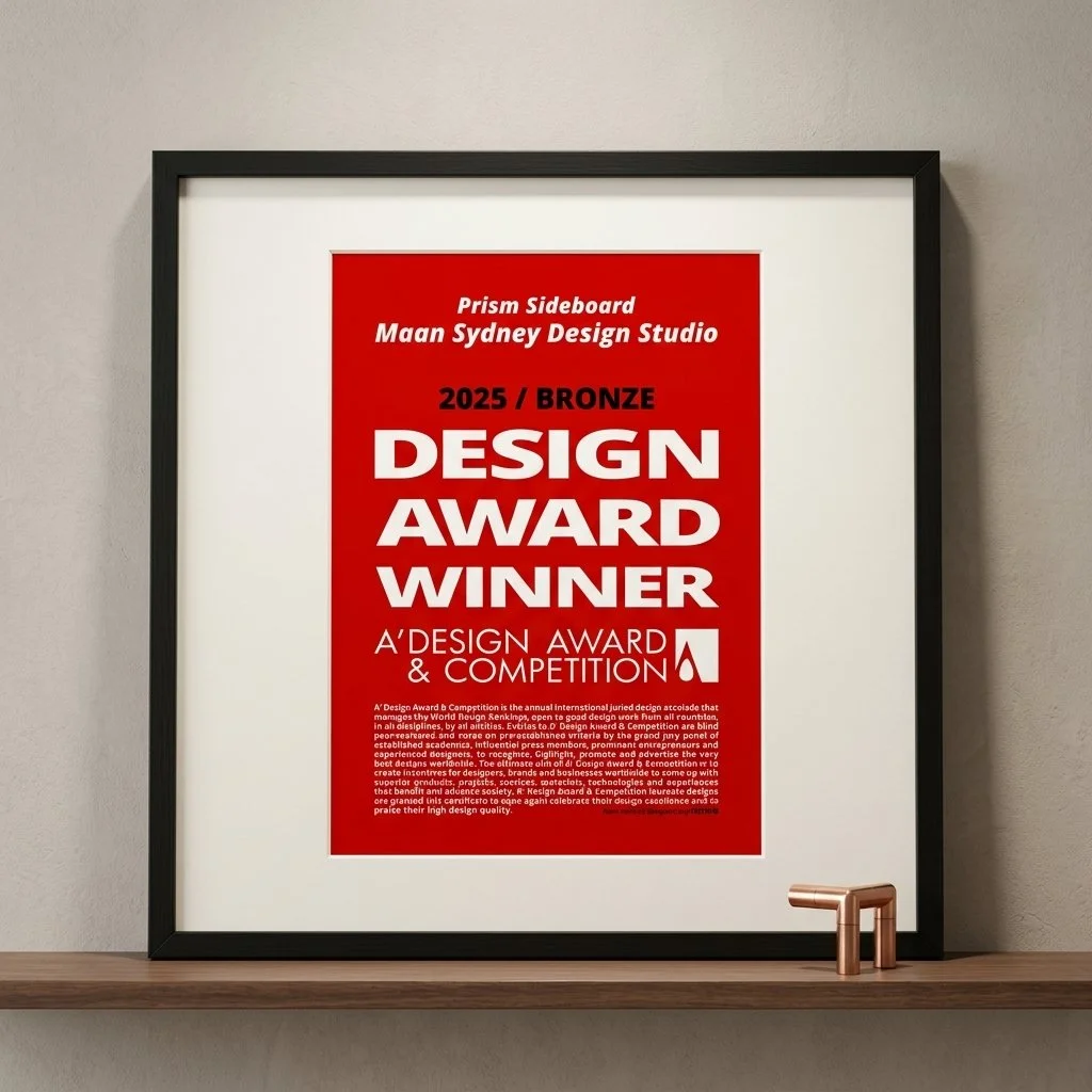 Framed award certificate on a wall, with red background and white text, recognizing a design award winner.