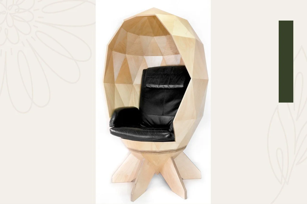A modern wooden pod chair with geometric patterns and a built-in black leather armchair inside.