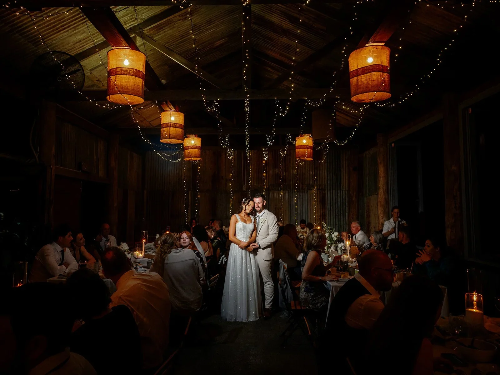 Chloe and James sharing a moment on the dancefloor under fairy lights and lanterns at their Yandina Station reception — Sean Reefman Photography