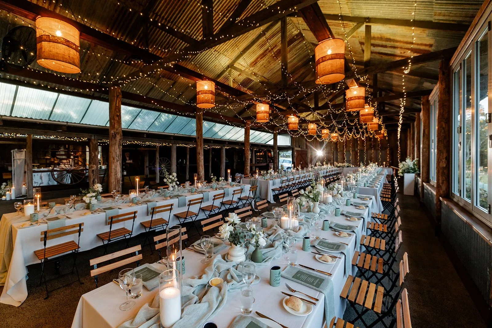 Wide interior view of the reception barn set for dinner — Sean Reefman Photography