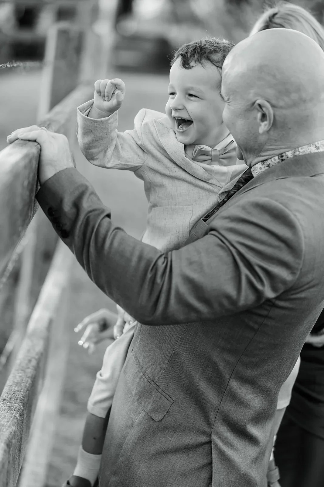 James laughing while holding a child up in the air outdoors — Sean Reefman Photography