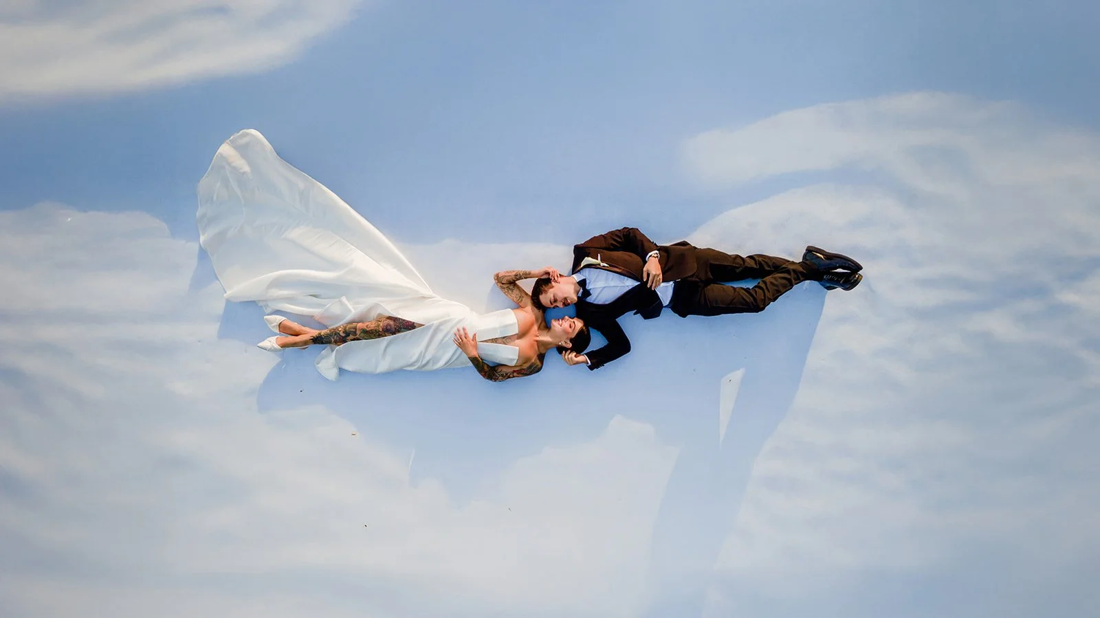 Aerial couple portrait of Cherry and Nick lying on the ground with wedding dress veil flowing — Jimbour House wedding by Sean Reefman Photography