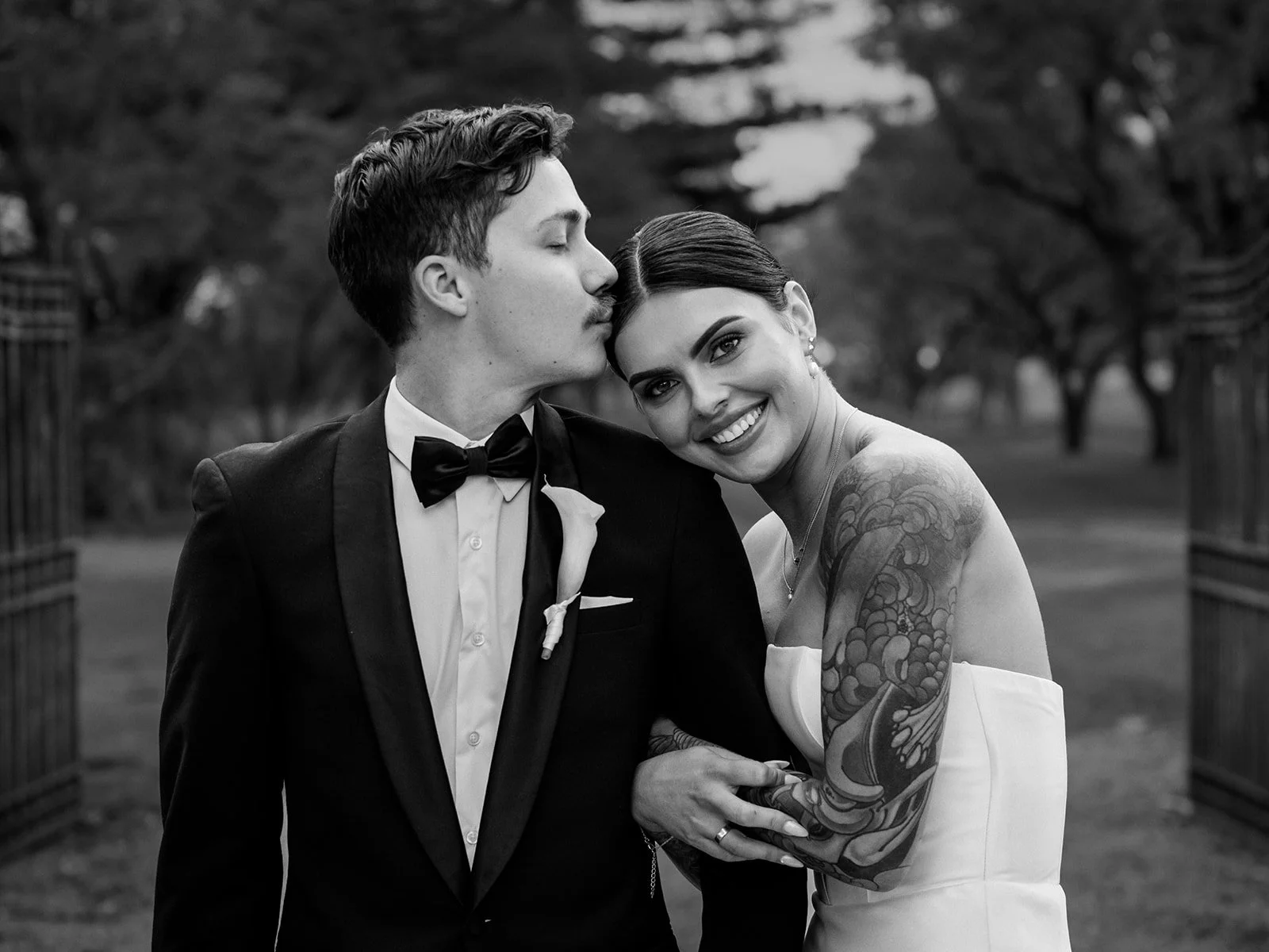 Black and white couple portrait of Nick kissing Cherry's cheek while she smiles at camera — Jimbour House wedding by Sean Reefman Photography