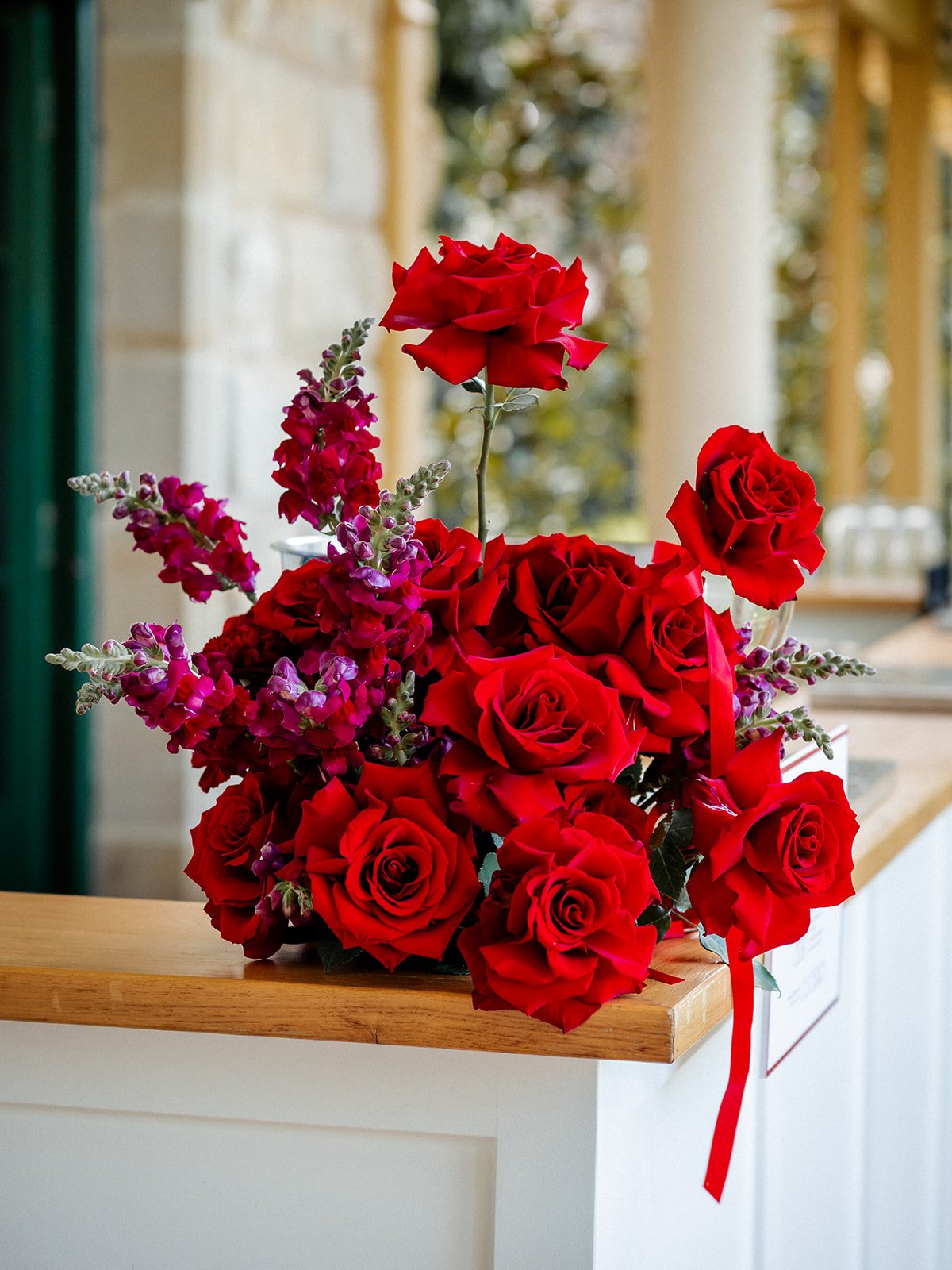 Red rose ceremony floral arrangement on ledge at Jimbour House — Cherry and Nick wedding by Sean Reefman Photography
