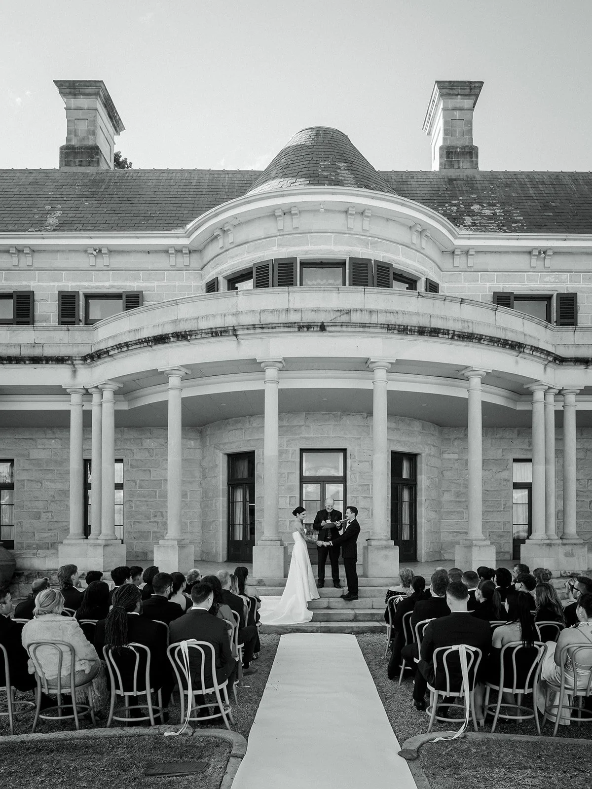 Black and white wide shot of outdoor ceremony at Jimbour House with full guest seating — Sean Reefman Photography
