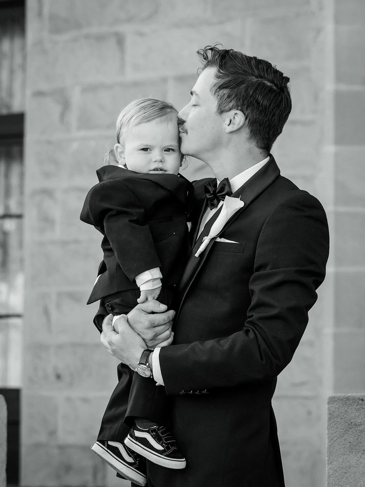Nick the groom kissing baby in black and white outside Jimbour House — Sean Reefman Photography