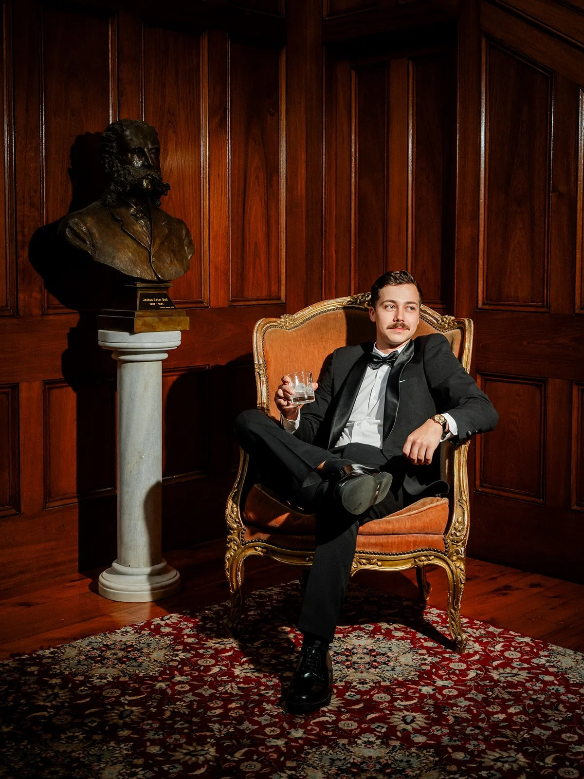 Nick the groom portrait seated inside Jimbour House in ornate chair with whiskey glass — Sean Reefman Photography
