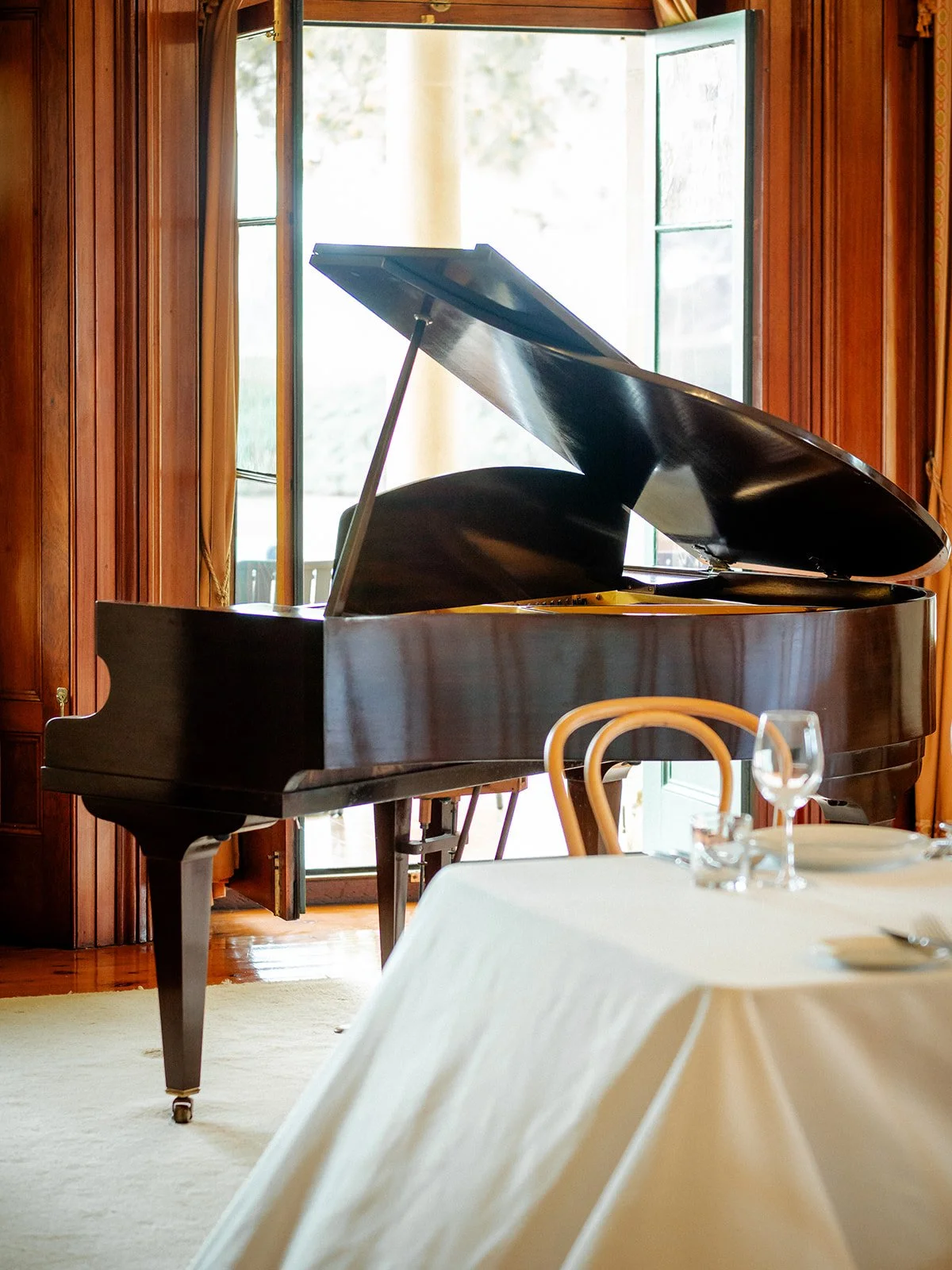 Grand piano in the reception room at Jimbour House with white tablecloth and glassware — Sean Reefman Photography