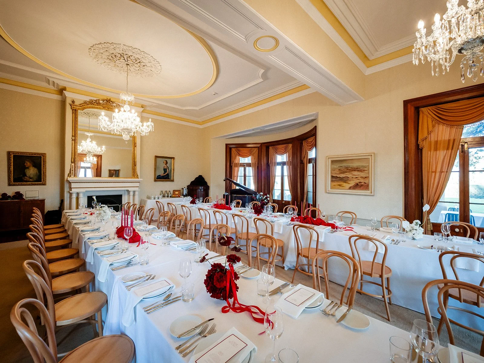 Jimbour House reception room with crystal chandeliers, red florals and white tablecloths — Darling Downs wedding by Sean Reefman Photography
