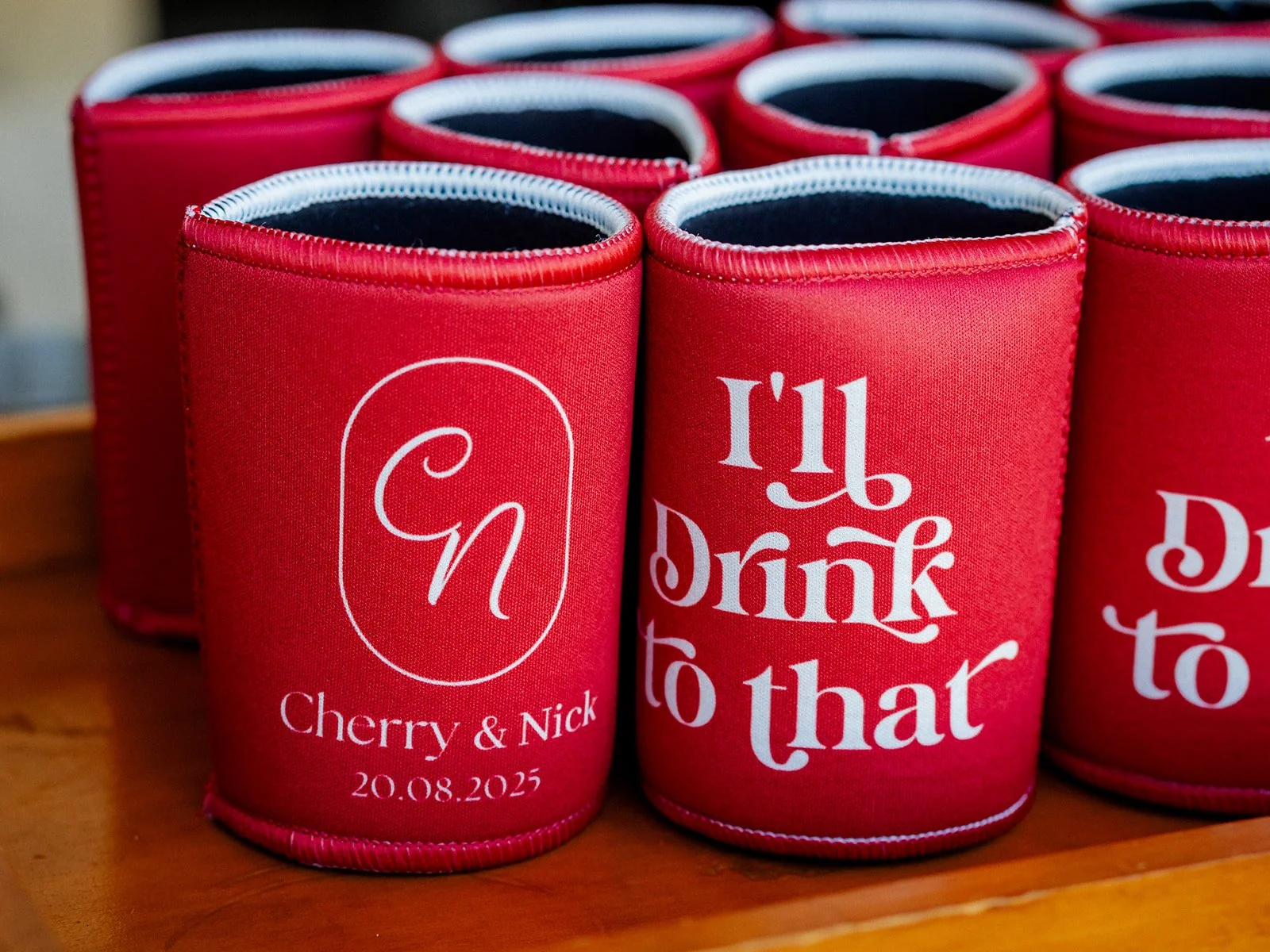 Red custom stubby holders reading Cherry and Nick 20 August 2025 — Jimbour House wedding details by Sean Reefman Photography