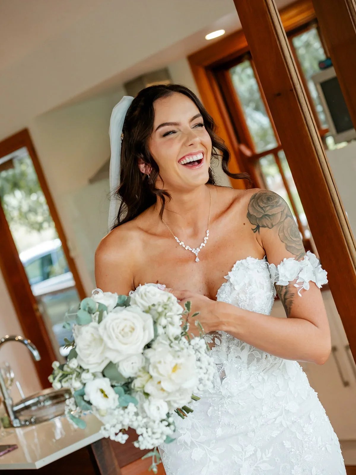Chloe laughing while holding her bouquet in the doorway before the ceremony — Sean Reefman Photography