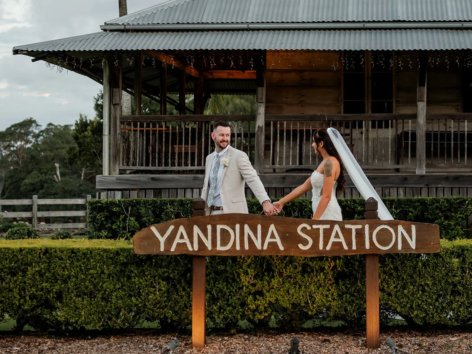 Yandina Station venue signage with the couple walking in the background — Sean Reefman Photography