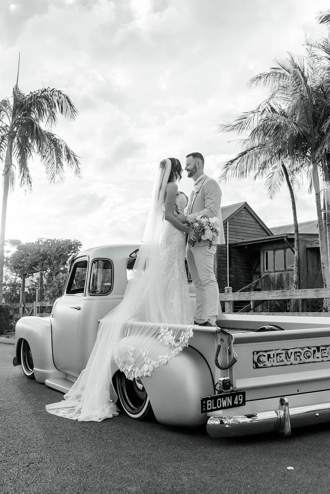 Chloe and James on the vintage truck with the venue in the background — Sean Reefman Photography