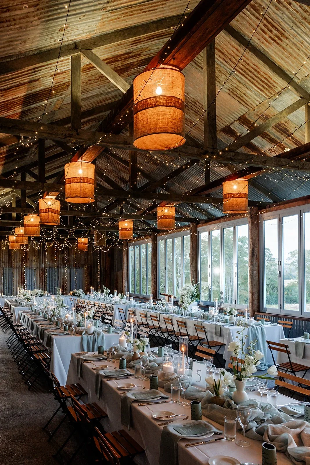 Reception barn dressed with lanterns and fairy lights over the dinner tables — Sean Reefman Photography