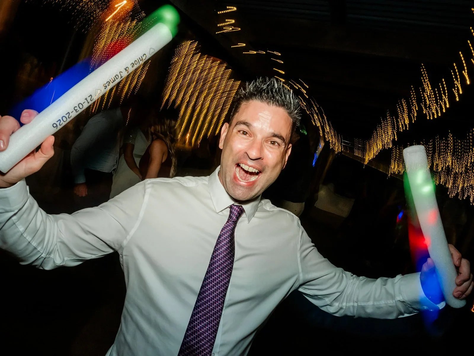 James dancing with glow sticks raised on the dancefloor — Sean Reefman Photography