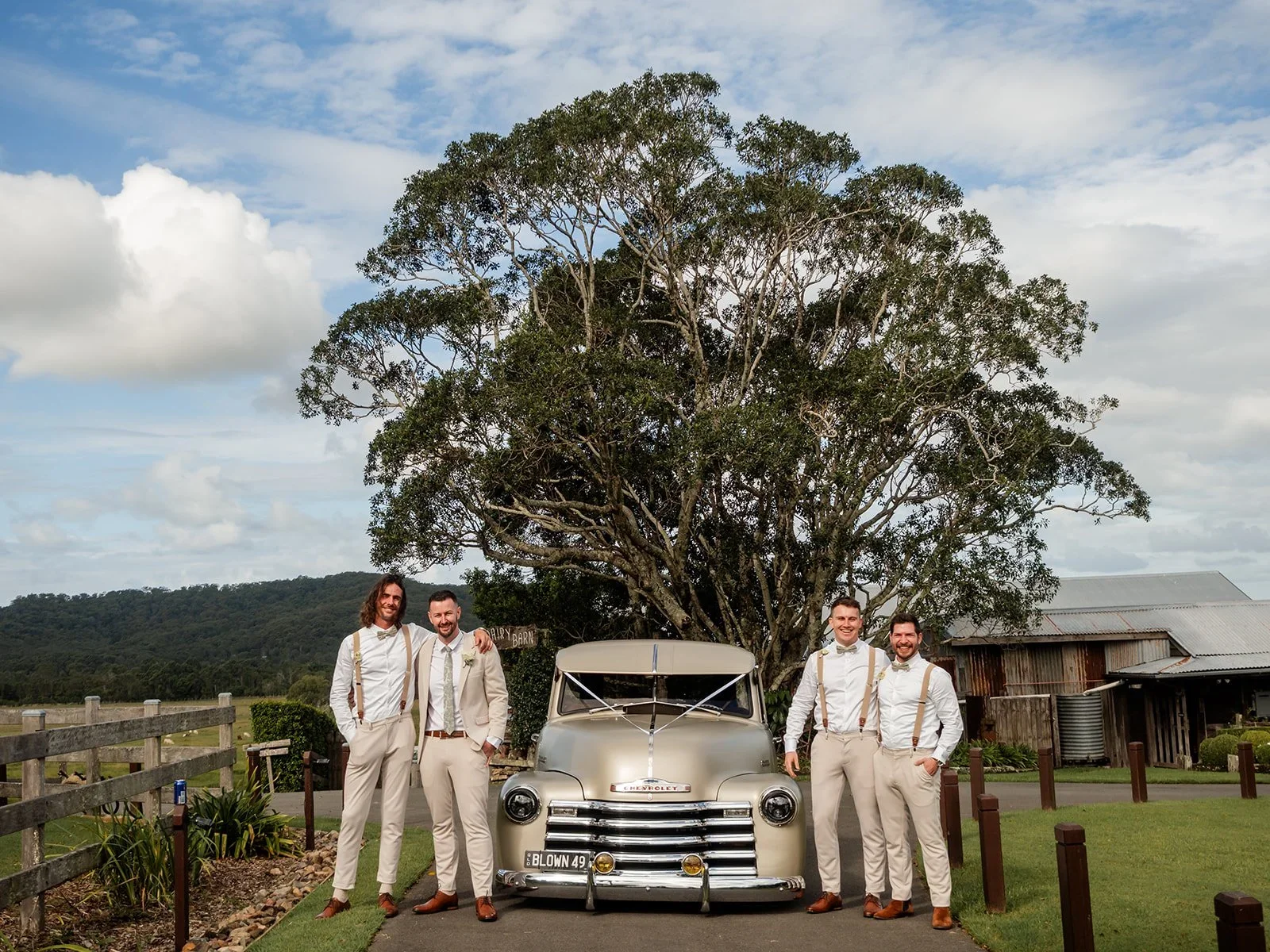 Groom and groomsmen posing beside a vintage car at Yandina Station — Sean Reefman Photography