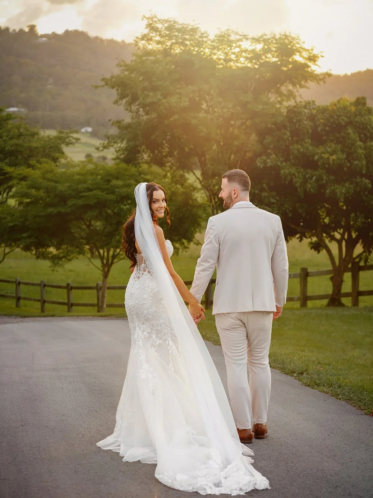 Chloe and James walking hand in hand down a sunlit path — Sean Reefman Photography