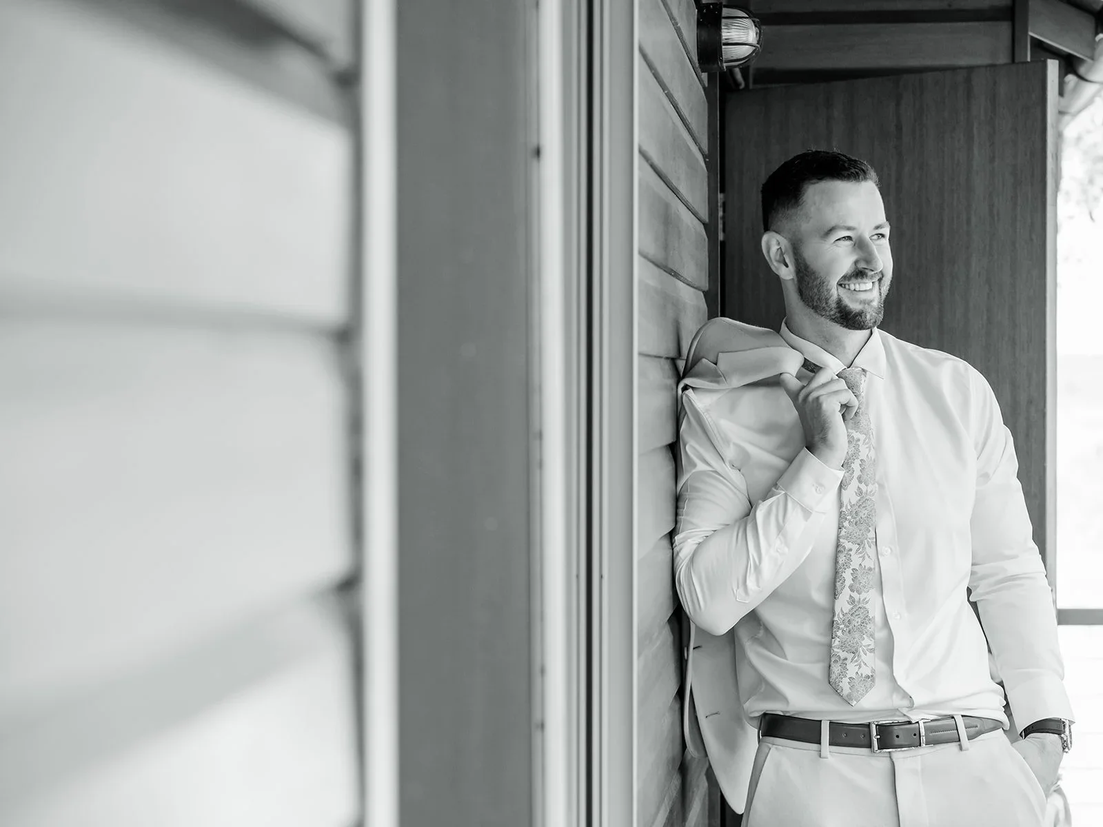 James adjusting his tie in a black and white portrait before the ceremony — Sean Reefman Photography