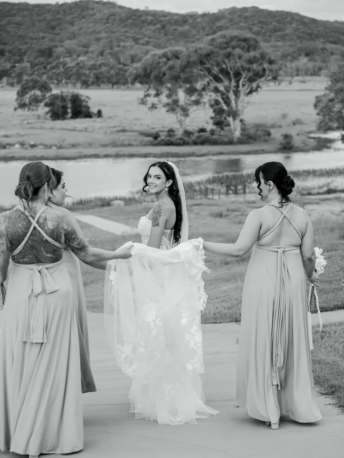 Bridesmaids gathered around Chloe's dress in a playful black and white moment — Sean Reefman Photography