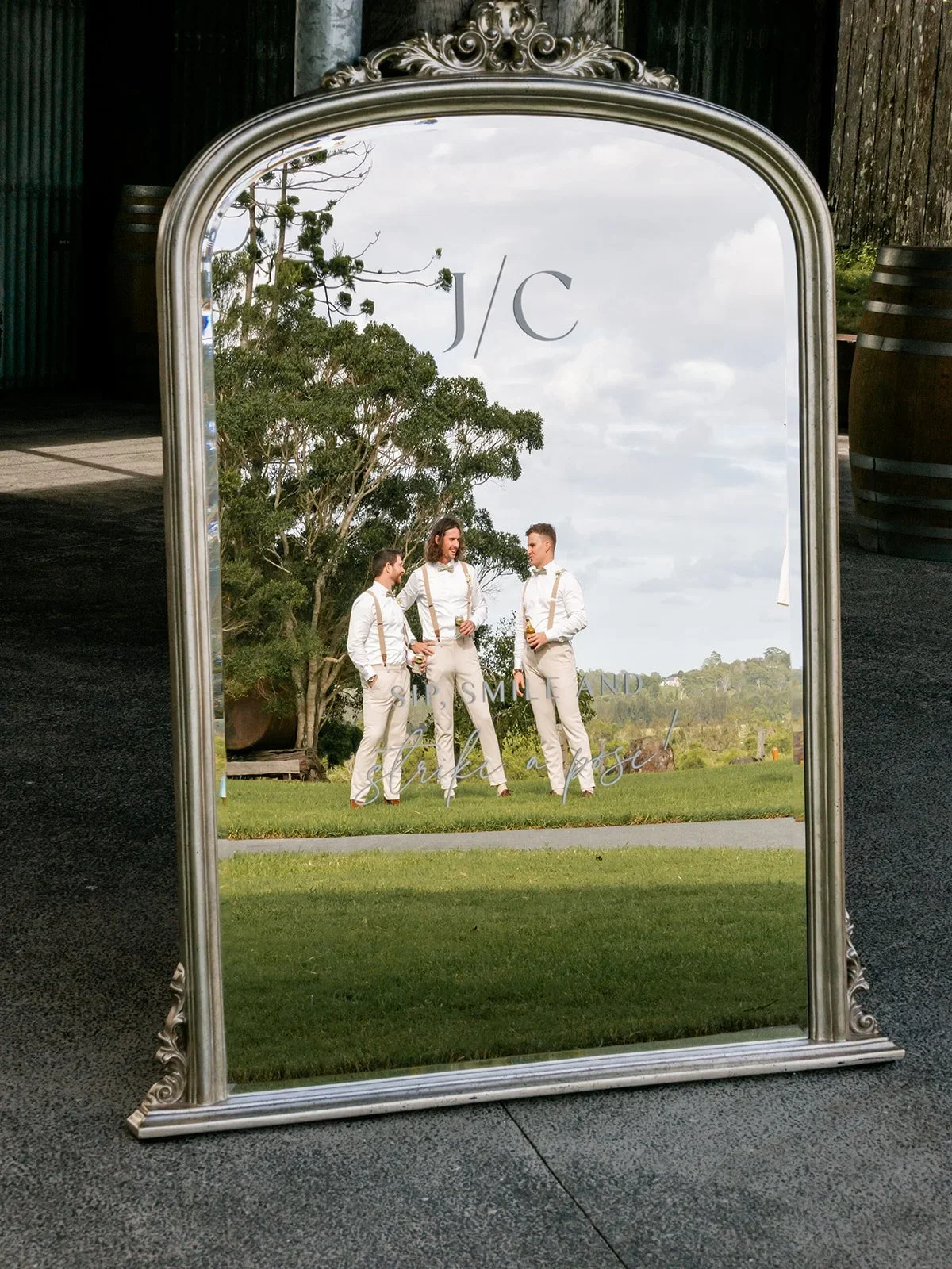 Groomsmen reflected in an ornate mirror monogrammed with the couple's initials — Sean Reefman Photography