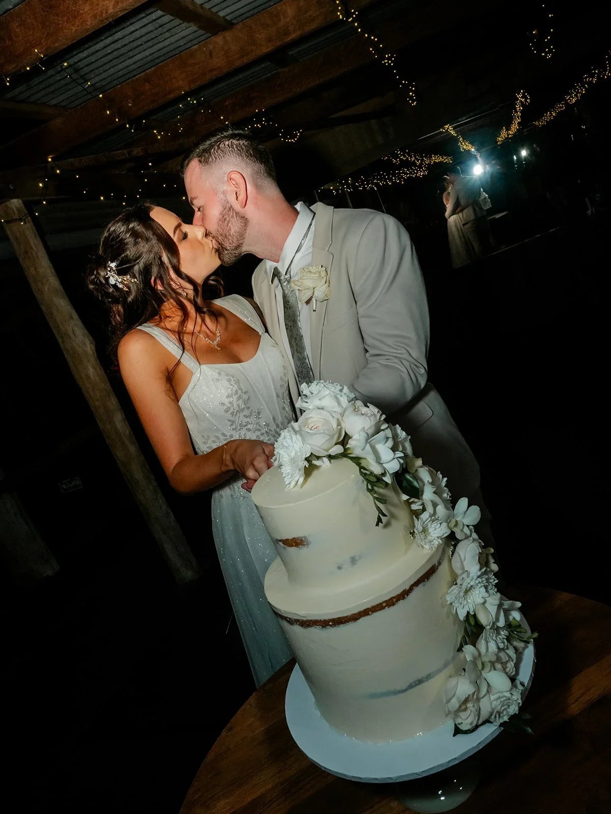 Chloe and James sharing a kiss while cutting their wedding cake — Sean Reefman Photography