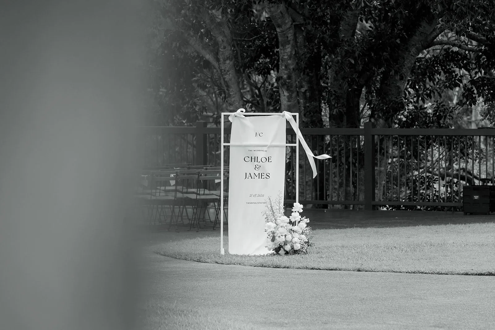 Black and white photo of the wedding welcome sign styled with florals — Sean Reefman Photography