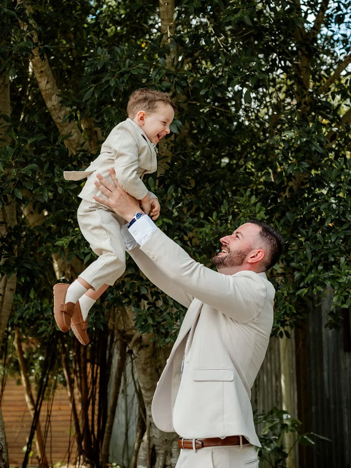 James lifting a baby into the air laughing during the wedding day — Sean Reefman Photography