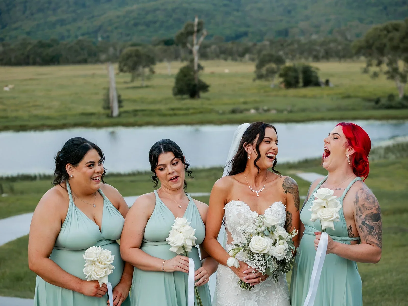 Bridesmaids laughing together in a group portrait in their sage green dresses — Sean Reefman Photography