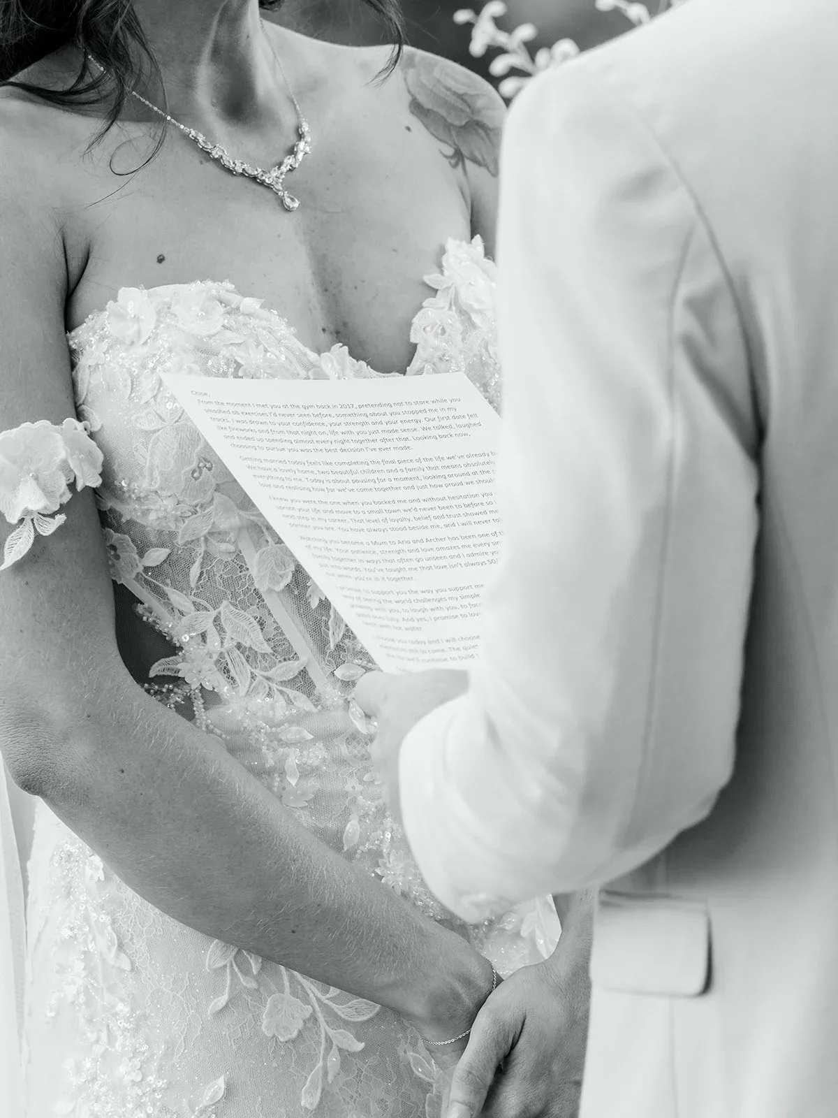 Detail of Chloe's lace dress while she holds her vows in black and white — Sean Reefman Photography