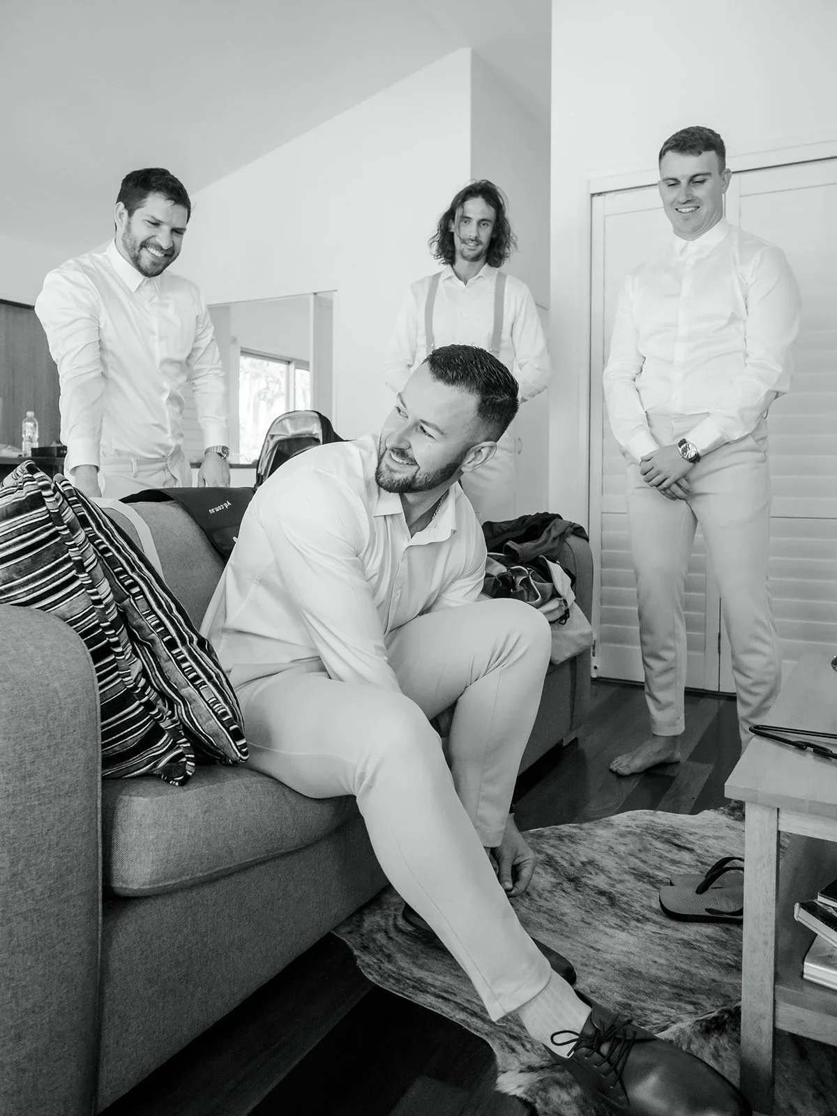 Groom and groomsmen laughing together while getting ready in black and white — Sean Reefman Photography