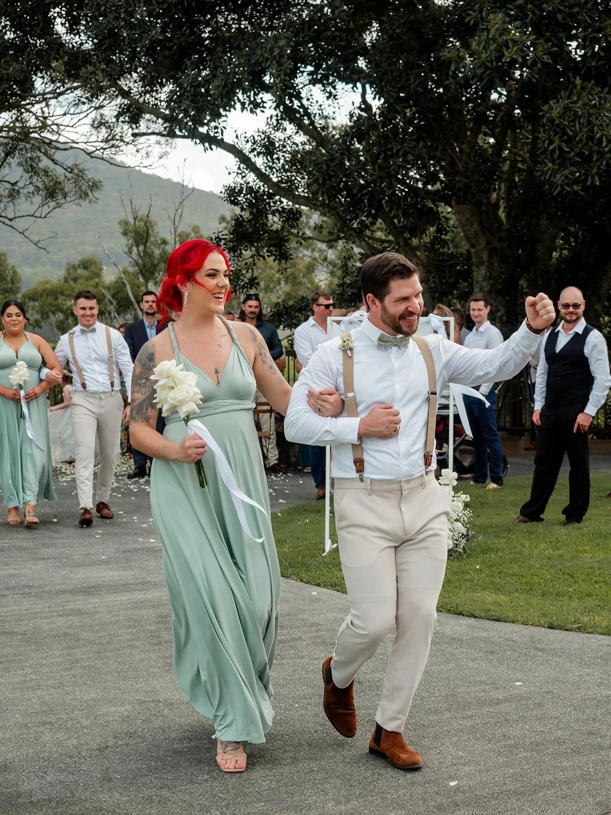 A bridesmaid in sage green walking down the aisle — Sean Reefman Photography