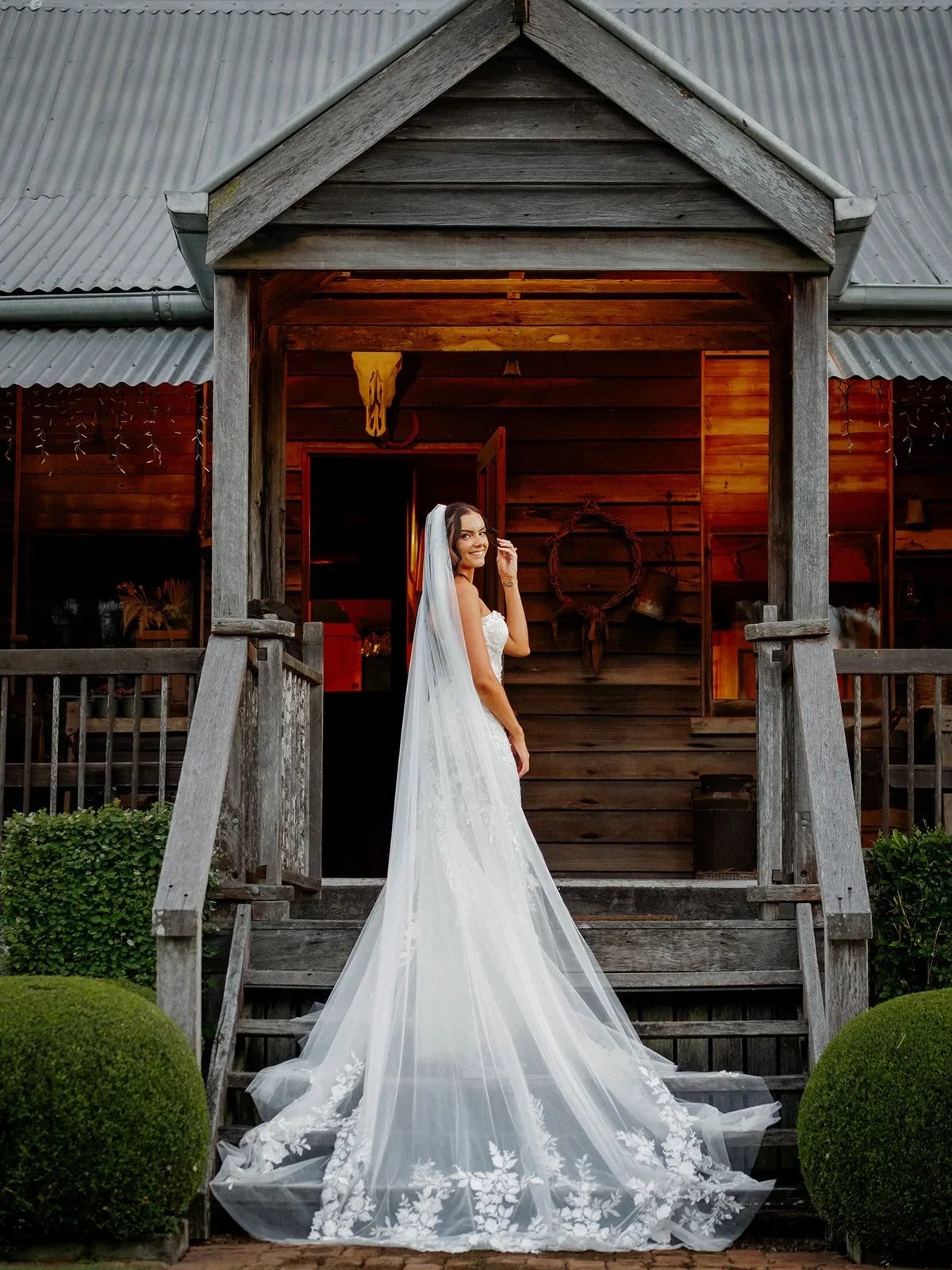 Chloe on the veranda steps with her veil flowing in the breeze — Sean Reefman Photography