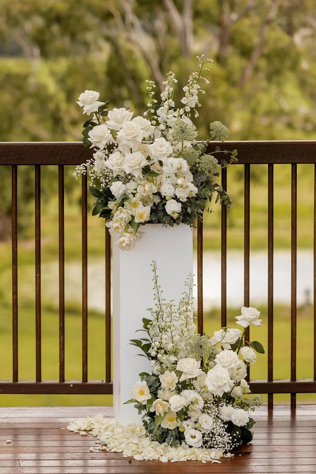 White floral arrangement styled on a stand at the ceremony entrance — Sean Reefman Photography