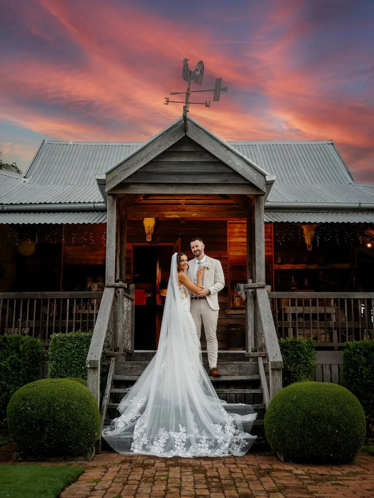 Chloe and James at the venue entrance under a vivid sunset sky — Sean Reefman Photography