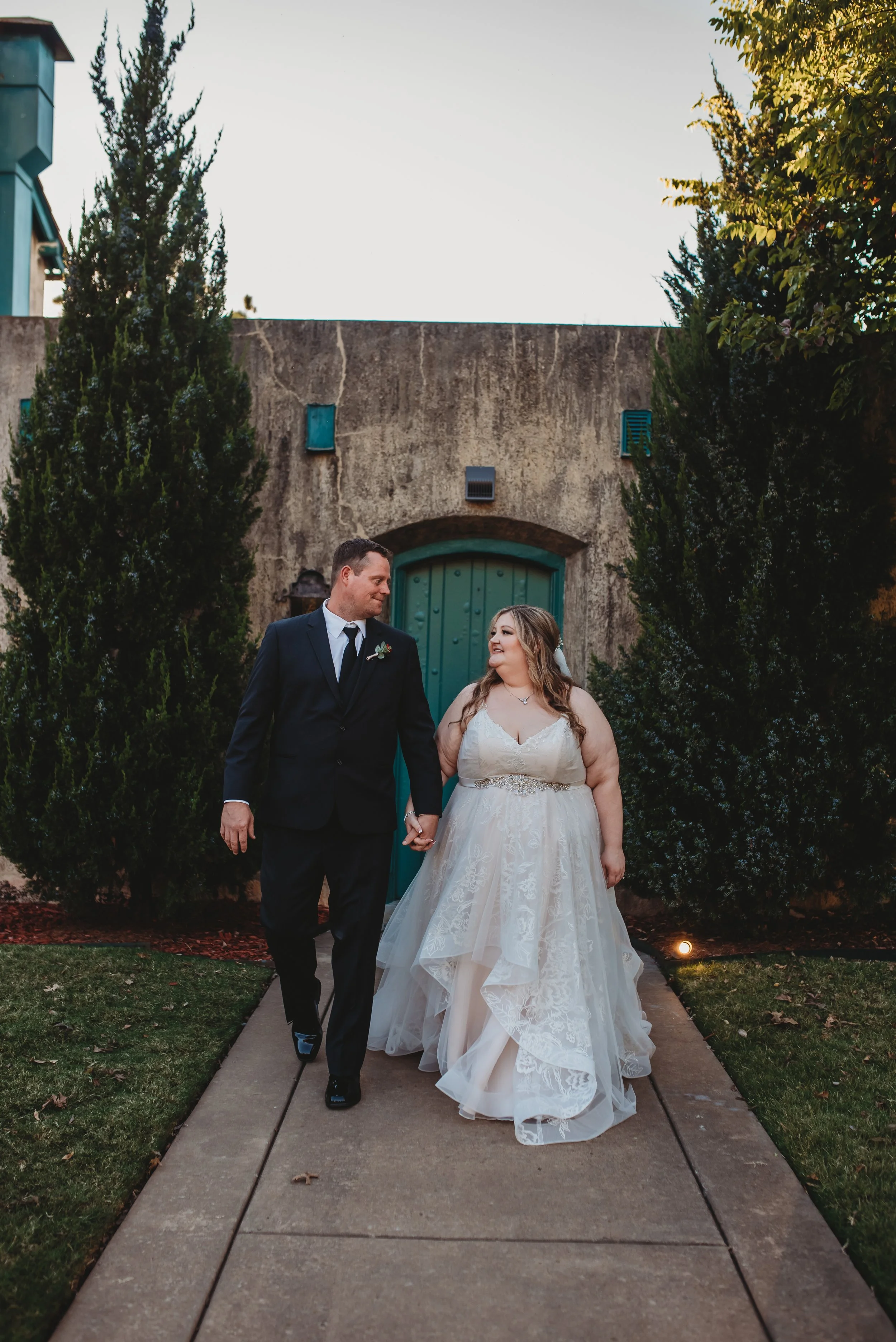 Tulsa couple holding hands and walking towards camera best Tulsa wedding photographer