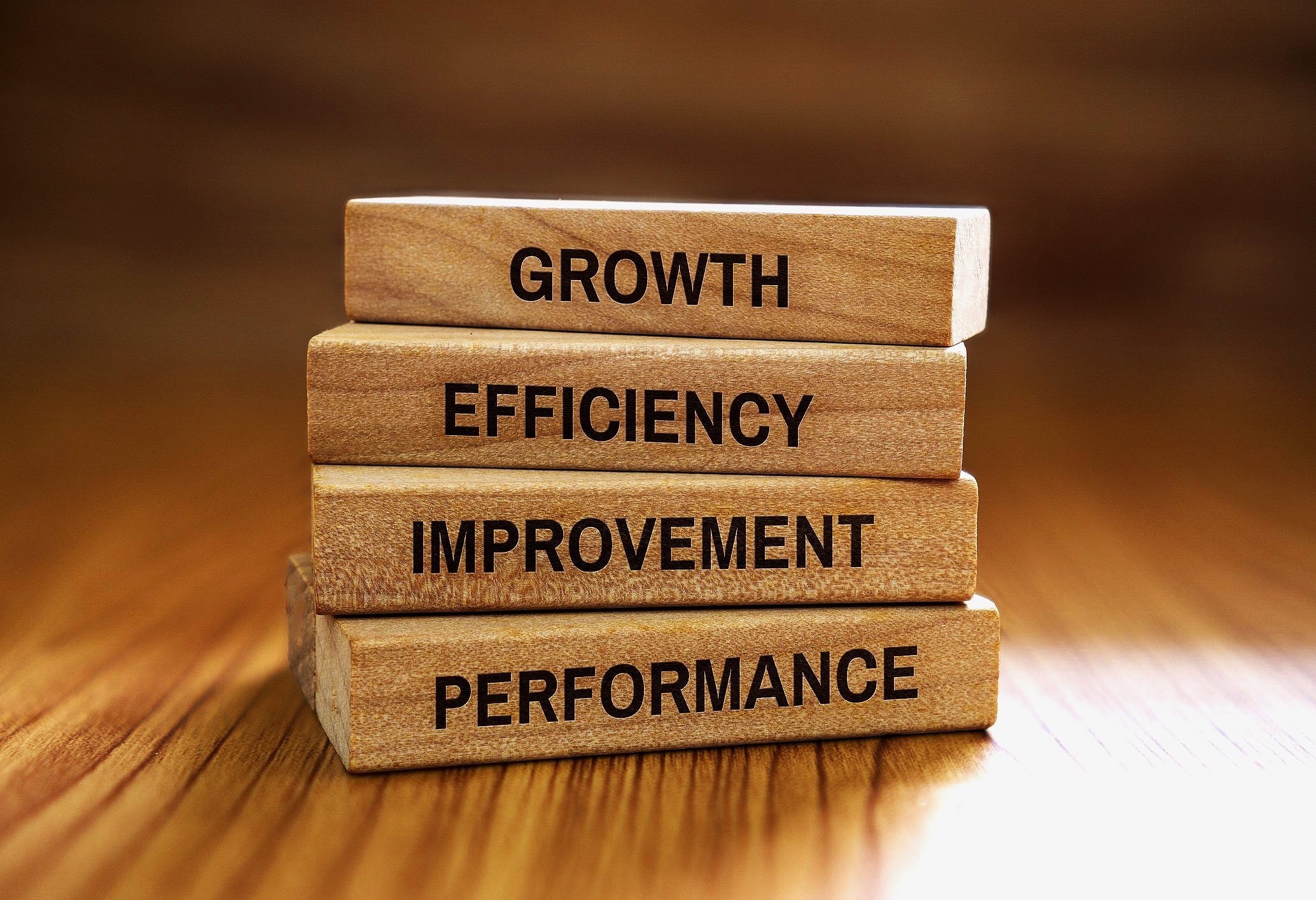 Stacked wooden blocks with words: Growth, Efficiency, Improvement, Performance.
