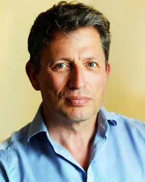 Portrait of a man wearing a blue shirt with a neutral expression